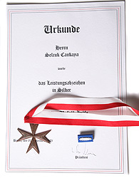 Urkunde für Herrn Selcuk Cankaya über das Leistungsabzeichen in Silber, mit Ordenskreuz, rot-weißem Band und Anstecknadel